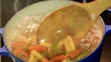 Renkli makarna bir tencerede kaynar