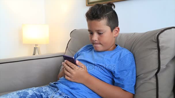 Niño usando el teléfono inteligente en casa — Vídeo de stock