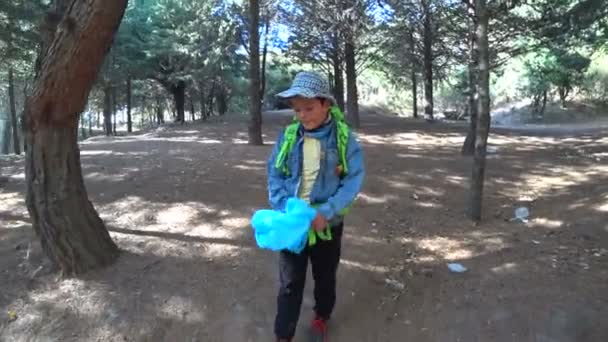 Young boy picking up trash in nature 2 — Stock Video