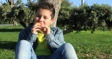 Genç çocuk 2 açık havada kruvasan yemek