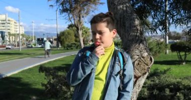 Genç çocuk bir lolipop 2 açık havada, yalama