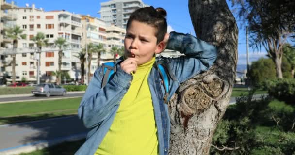 Genç çocuk dışarıda, lolipop yalamak — Stok video