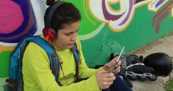 Ung pojke med hörlurar använder digitala tablett 5 — Stockvideo