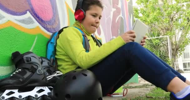 Νεαρό αγόρι με ακουστικά χρησιμοποιώντας ψηφιακή δισκίο 4 — Αρχείο Βίντεο