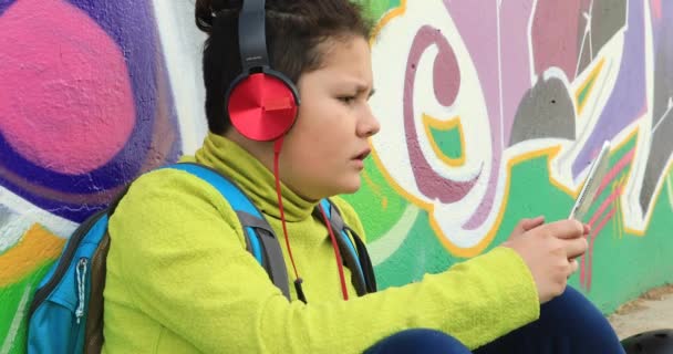 Νεαρό αγόρι με ακουστικά χρησιμοποιώντας ψηφιακό tablet 7 — Αρχείο Βίντεο