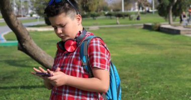 Yeşil bahar parkta duran, smartphone teknolojisi, Internet iletişim ve insan kavramı, Smartphone bağımlılığı konuşmak mutlu bir varoluş çocuk portresi