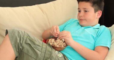 Fıstık yemek ve tv seyretmek genç çocuk