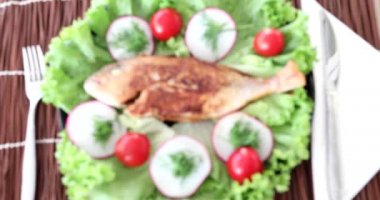 Tabağında salata olan fırında balık.