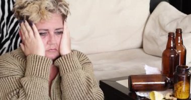 Depresyondaki sefil kadın, yerde tek başına oturuyor ve alkol içiyor.