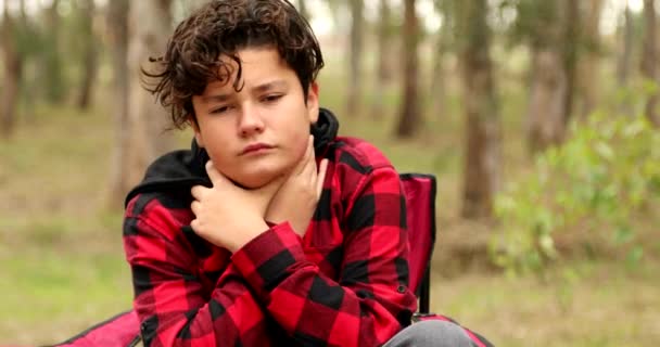 弱い若いです男の子で屋外で病気インフルエンザで座っているアームチェアと休憩 — ストック動画