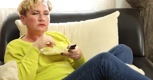 Retrato Uma Mulher Loira Relaxada Sentada Sofá Comendo Junk Food — Vídeo de Stock