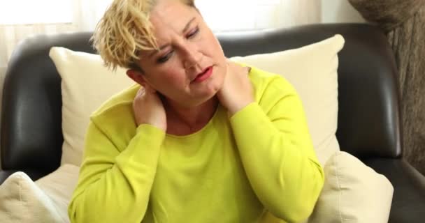 Mulher Dolorosa Sentada Sofá Casa Massageando Pescoço Ombro — Vídeo de Stock