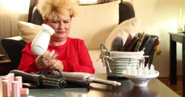 Orta yaşlı mutsuz bir kadının portresi kısa sarı saçlarını tutuyor ve kırılgan saç bakımı sorunlarına bakıyor, güzellik tedavi konsepti