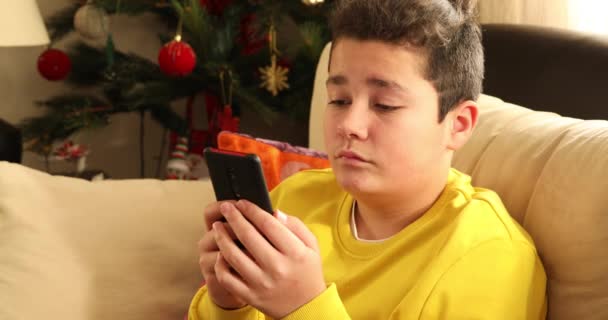 Πορτρέτο Ενός Χαλαρωμένου Έφηβου Αγοριού Κάθεται Στον Καναπέ Έξυπνο Τηλέφωνο — Αρχείο Βίντεο
