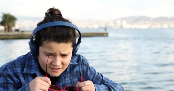 Deniz Kenarında Kameraya Gülümseyen Güneş Gözlüklü Yakışıklı Bir Gencin Portresi — Stok video