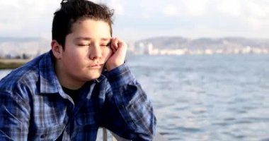 Portrait Of A Young Handsome Sad Teenage Boy Looking To Camera At The Seaside