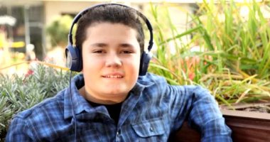 Portrait Of A Young Handsome Caucasian Teenage Boy Listening To Music In The Streets Outdoors