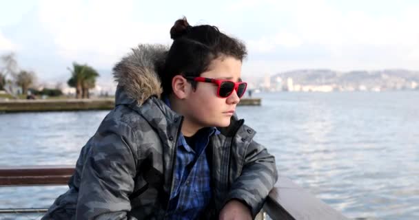 Portrait Handsome Teenage Boy Sitting Seaside Feel Cold Try Keep — Stockvideo