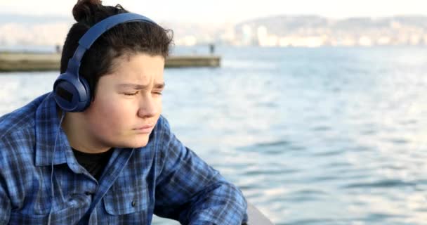 Portrait Young Handsome Sad Teenage Boy Headphone Looking Camera Seaside — Stock Video