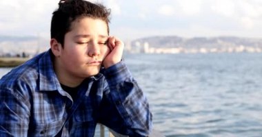Portrait Of A Young Handsome Sad Teenage Boy Looking To Camera At The Seaside