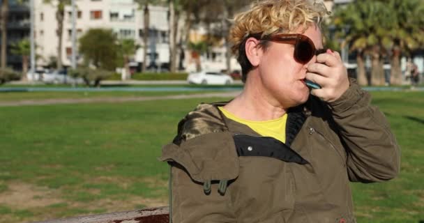 Middle Aged Woman Seated Park Bench Taking Asthma Treatment Inhaler — Stock Video