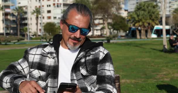 Glücklicher Mann Mittleren Alters Nutzt Smartphone Stadtpark — Stockvideo