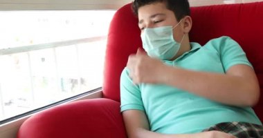 Pencerelere bakan üzgün bir gencin portresi. Koronavirüs salgını sırasında ev izolasyonu otomobil karantinası.