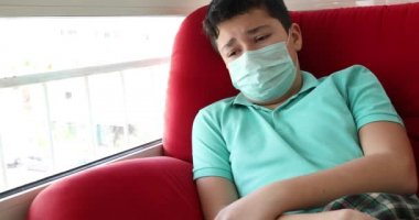 Pencerelere bakan üzgün bir gencin portresi. Koronavirüs salgını sırasında ev izolasyonu otomobil karantinası.