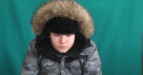穿着保暖衣服的小男孩冬季肖像与彩色键绿色屏风背景对比 — 图库视频影像