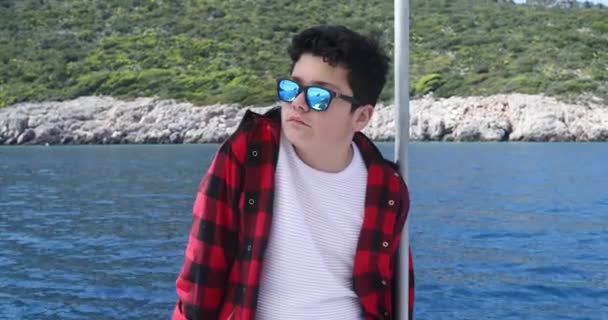 夏休みにヨットデッキでリラックスするハンサムな少年の肖像 旅行者の夏のコンセプト — ストック動画