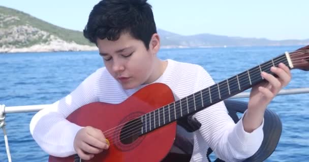 Young Boy Musician Yacht Deck Practicing Guitar While Travelling — Stock Video
