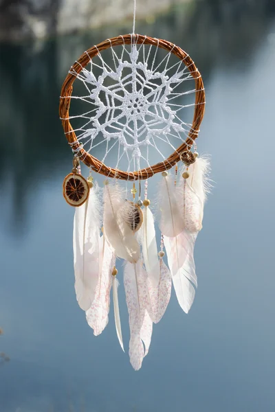 Handmade dream catcher with white doily on background of rocks a — Stock Photo, Image