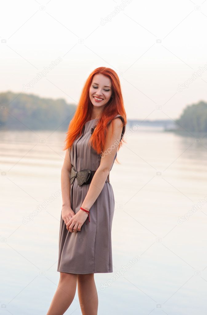 Outdoors portrait of beautiful smiling woman with red hair