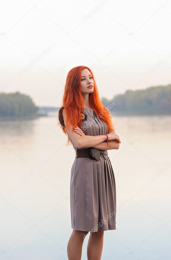 Outdoors portrait of beautiful smiling woman with red hair