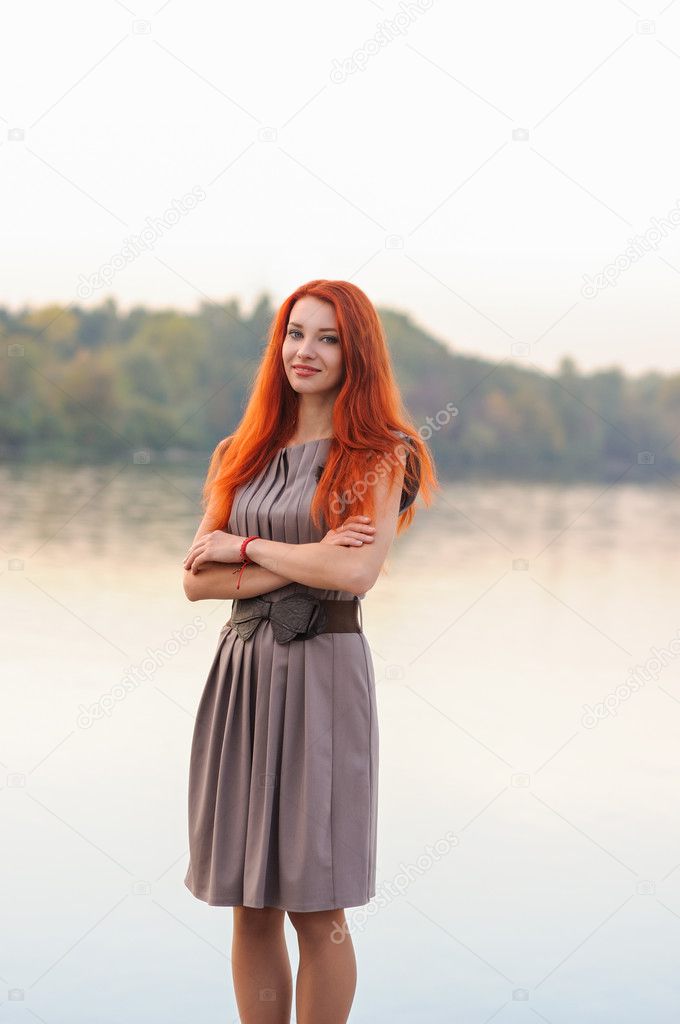 Outdoors portrait of beautiful smiling woman with red hair