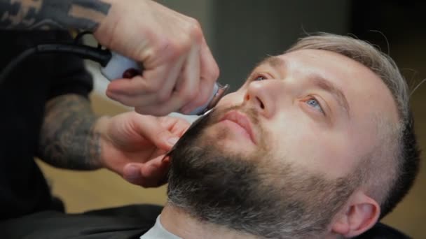 Mannen hairstyling en haircutting in een kapper winkel of haar salon. Man Kapper doen kapsel baard volwassen mannen in de mannen kapsalon. — Stockvideo