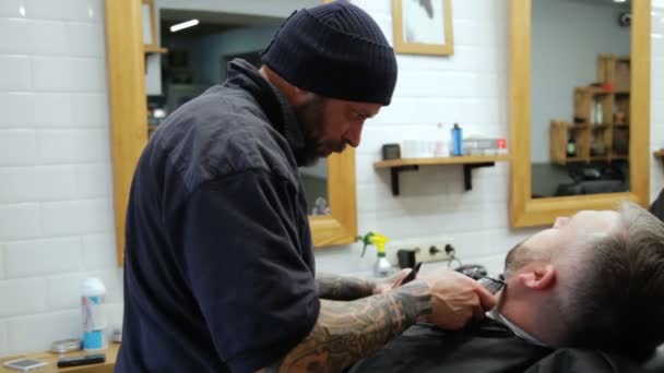 Mannen hairstyling en haircutting in een kapper winkel of haar salon. Man Kapper doen kapsel baard volwassen mannen in de mannen kapsalon. — Stockvideo