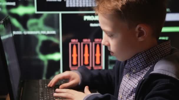 Jonge schooljongen prodigy - een hacker. Hacker op het werk. Veel van de cijfers op het computerscherm. — Stockvideo