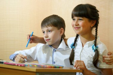 Çocuklar kağıt üzerinde çizin. Yaratıcılık ve eğitim kavramı. Beyaz bir kağıt (tablo üzerine renkli kalemler ile çocuk boyalar)