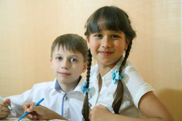 Children draw on paper. Creativity and education concept. The child paints with colored pencils on a white sheet of paper (table)