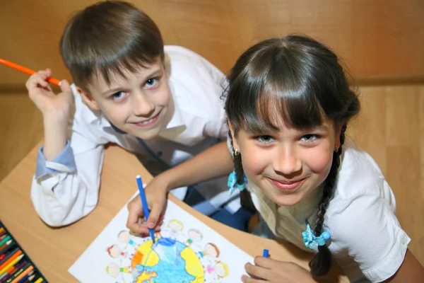 As crianças desenham no papel. Criatividade e educação conceito. A criança pinta com lápis coloridos em uma folha branca (mesa ) — Fotografia de Stock