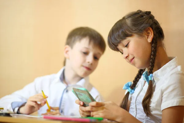 Children draw on paper. Creativity and education concept. The child paints with colored pencils on a white sheet of paper (table)