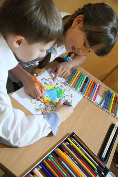 As crianças desenham no papel. Criatividade e educação conceito. A criança pinta com lápis coloridos em uma folha branca (mesa ) — Fotografia de Stock