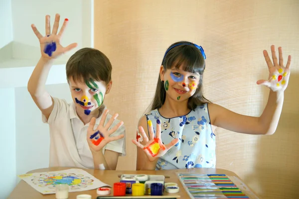 Joyful children with paints on their faces. Creativity and education concept. Children paints faces with colors. — Stock Photo, Image