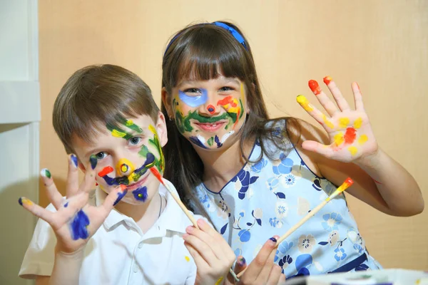 Joyful children with paints on their faces. Creativity and education concept. Children paints faces with colors. — Stock Photo, Image