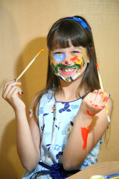 Crianças alegres com tintas no rosto. Criatividade e educação conceito. Menina com as mãos pintadas. Retrato de uma criança manchada com tintas . — Fotografia de Stock