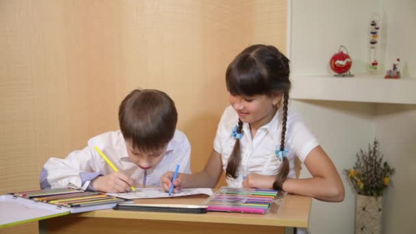 As crianças desenham no papel. Criatividade e educação conceito. A criança pinta com lápis coloridos em uma folha branca (mesa ) — Vídeo de Stock