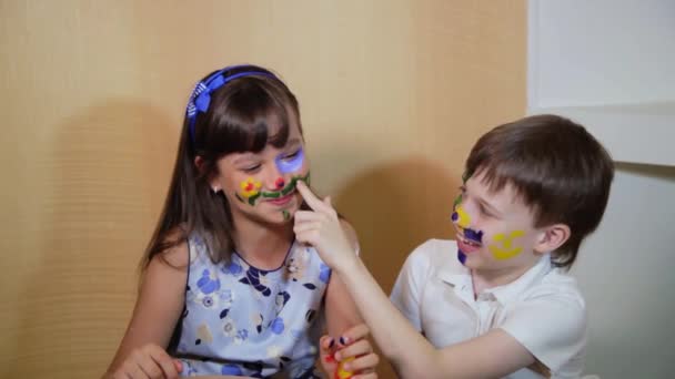 Niños alegres con pinturas en la cara. Dibujo. Concepto de creatividad y educación. Niños pintan caras con colores . — Vídeos de Stock