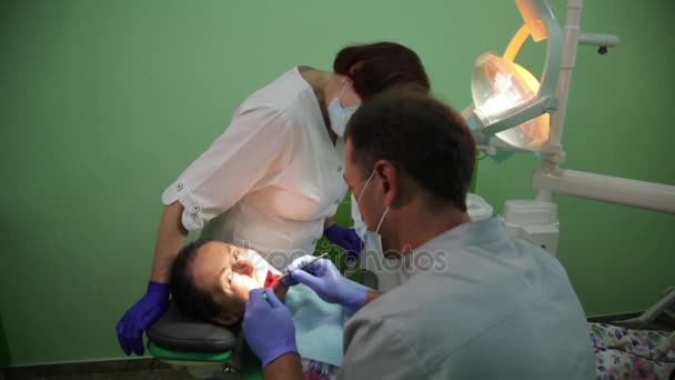 VINNITSA, UKRAINE, JULHO 20, 2017: Dentista que trata os dentes de um paciente com ferramentas dentárias na clínica odontológica. Odontologia . — Vídeo de Stock