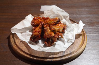 Acı sos, özel bira için hazırlanan tavuk kanatları. Ahşap plaka üzerinde sıcak soslu tavuk kanadı. 